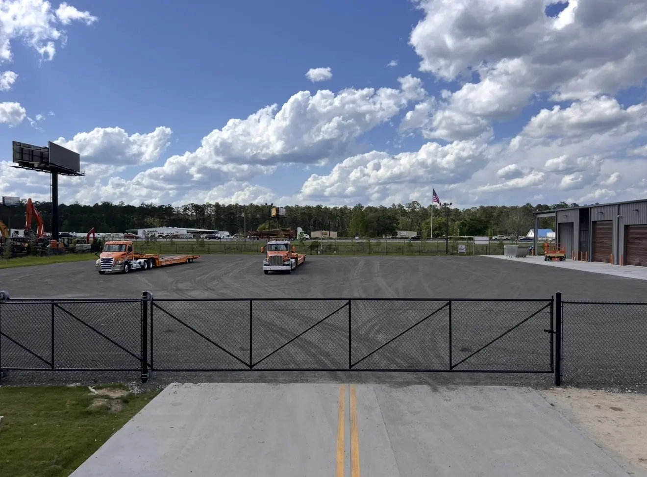 Wide black chain-link commercial entry gates and perimeter fence installed at EquipmentShare in Richmond Hill