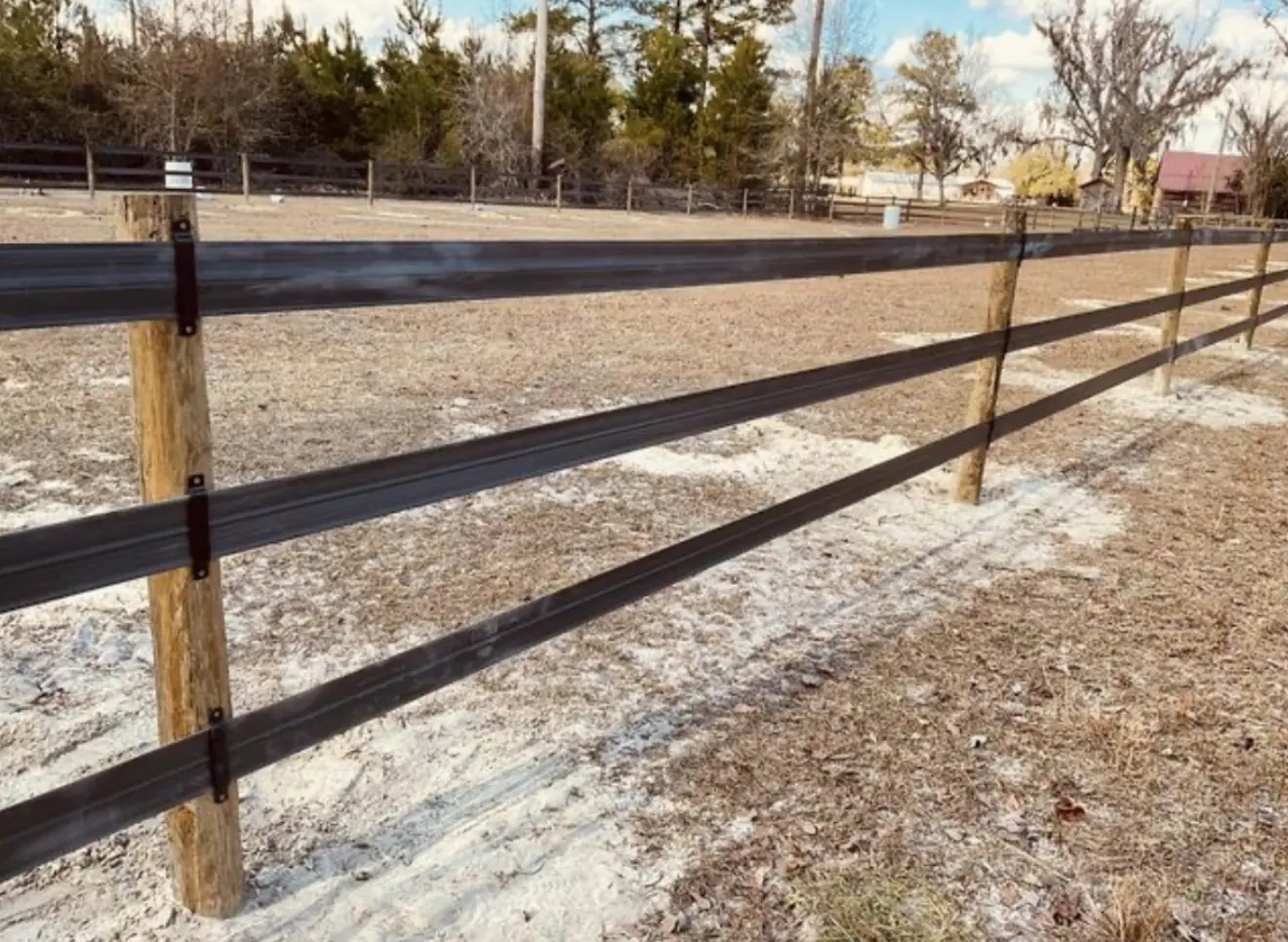Black flex-rail horse fence around a paddock