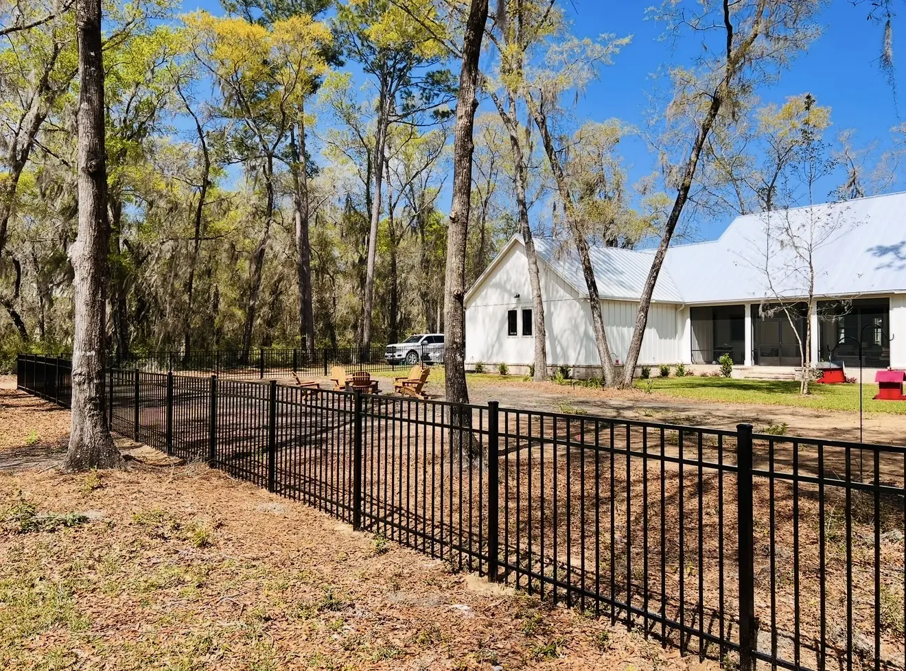 Black aluminum fence following a wooded residential property