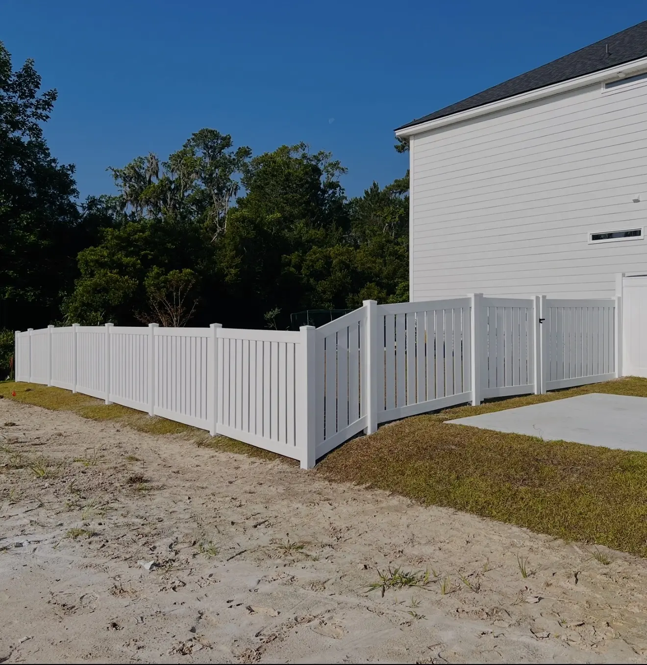 White vinyl picket fence surrounding a residential yard