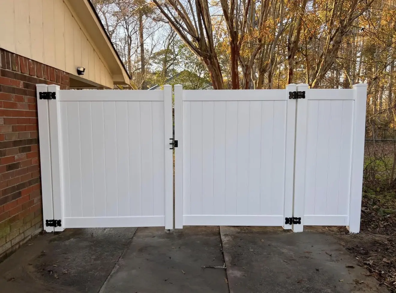 Pair of white vinyl privacy gates across a residential side yard