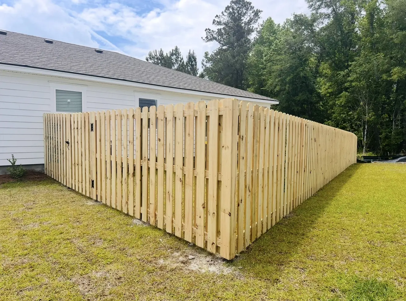 Pressure-treated shadowbox fence and matching walk gate enclosing a side yard